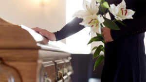 family member placing hand on casket after wrongful death