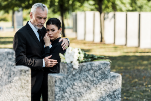 a grieving couple at a deceased person's death gravesite due to someone else's negligence