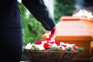 a woman placing flowers on someone's coffin during someone's civil lawsuits
