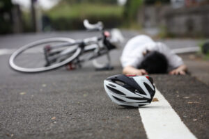 a bicycle helmet with an injured bicyclist in the background